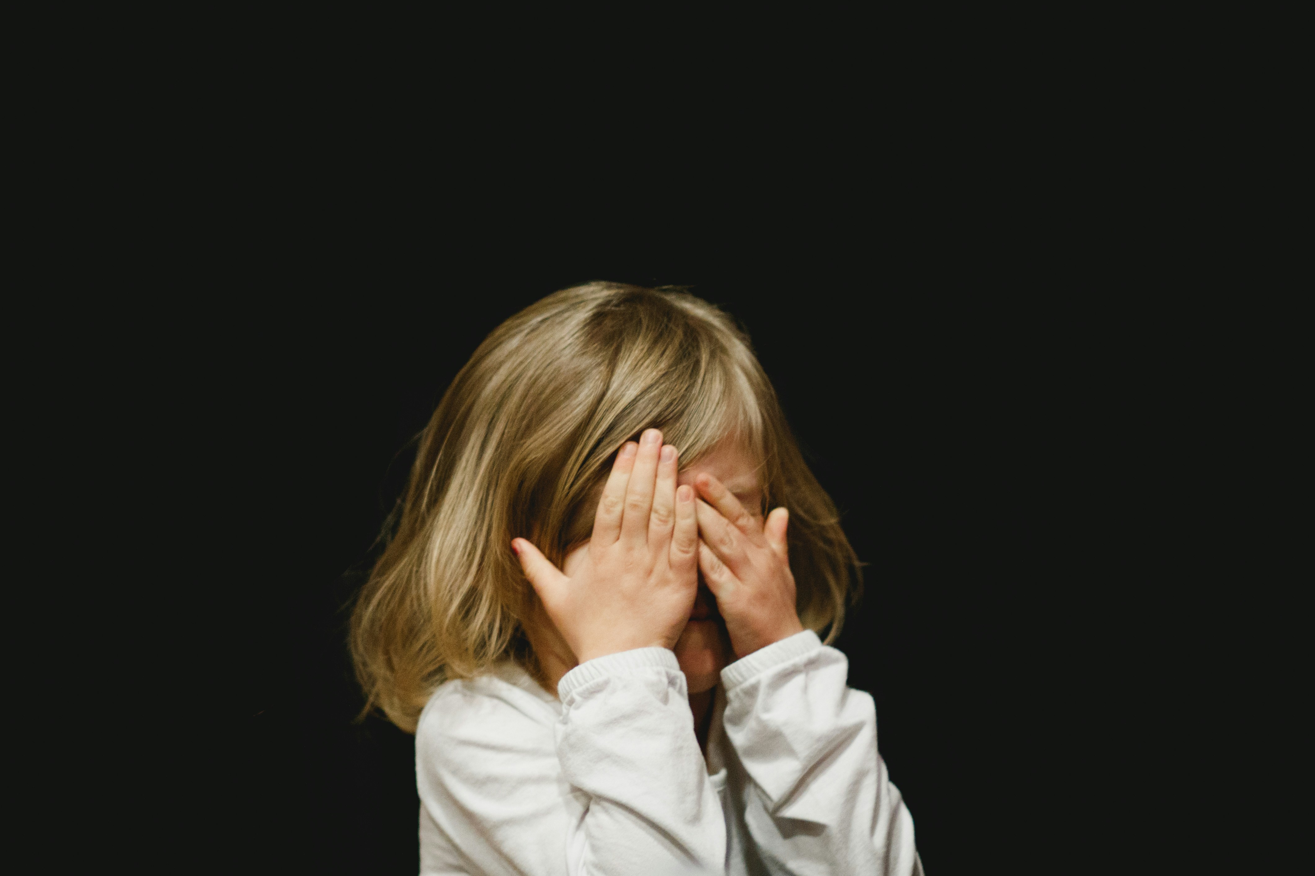 Child shielding their face, representing the need to protect every child